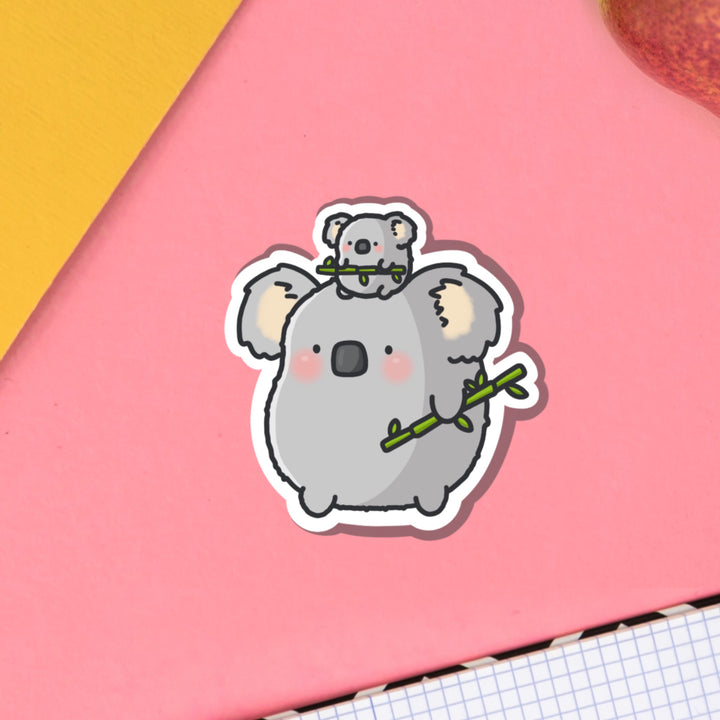Koala vinyl sticker on pink table with notebook