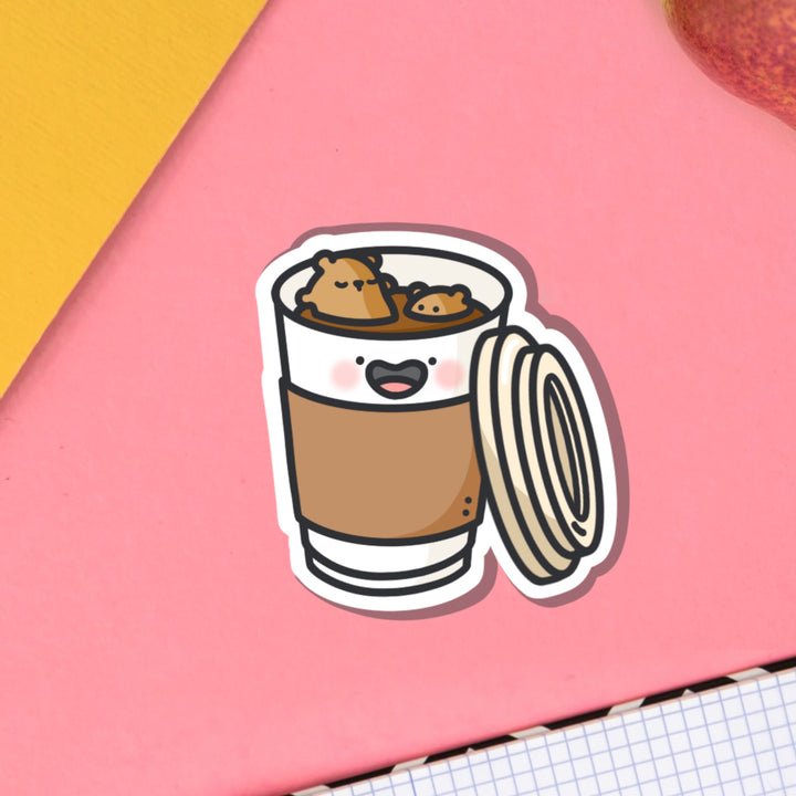 Bears bathing in coffee vinyl sticker on pink table and notebook
