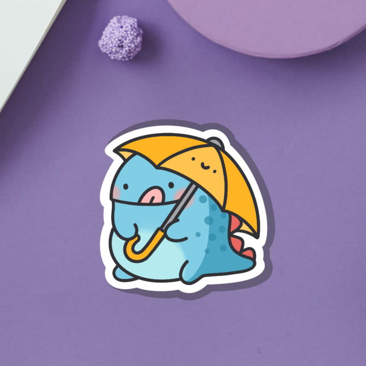 Dinosaur holding umbrella vinyl sticker on purple table