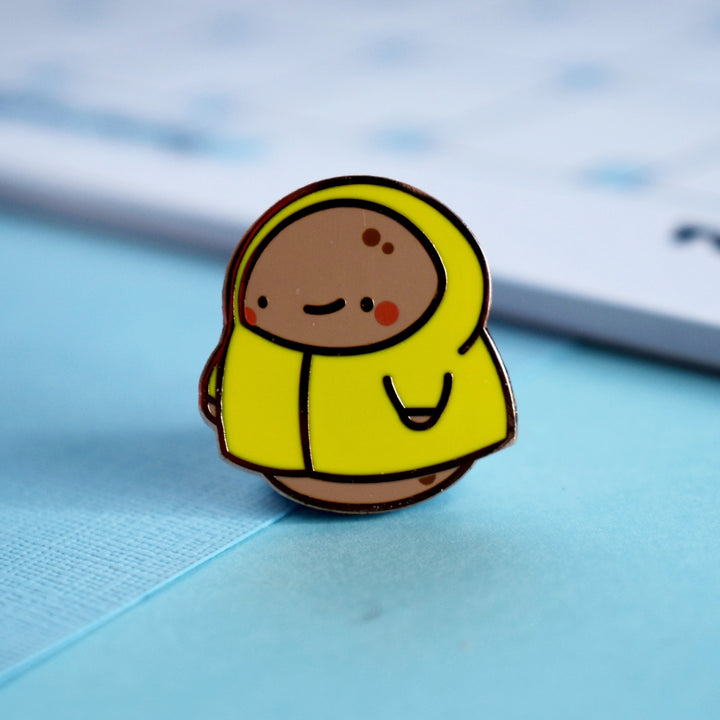 Potato wearing yellow raincoat enamel pin