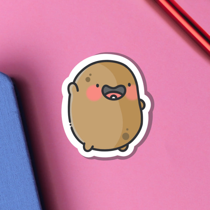 Potato waving vinyl sticker on pink table and notebook