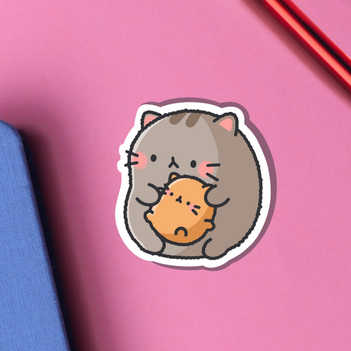 Cat holding baby kitty vinyl sticker on pink background