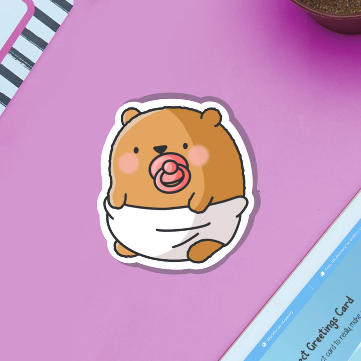 Bear dressed as baby vinyl sticker on purple table and ipad