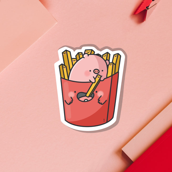 Pig sat in french fries vinyl sticker on pink table
