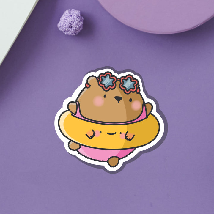 Bear dressed in beach outfit vinyl sticker on purple table