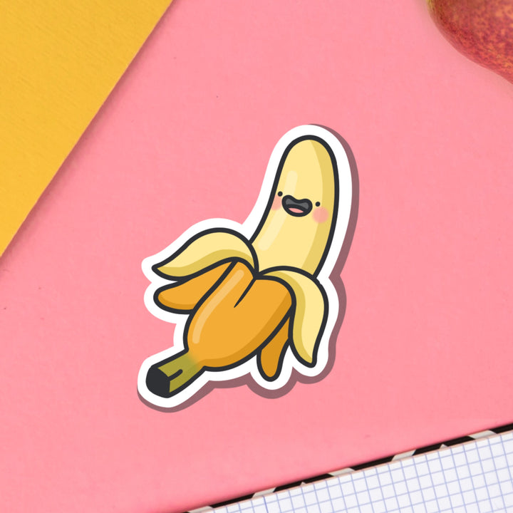 Happy banana vinyl sticker on pink table with notebook