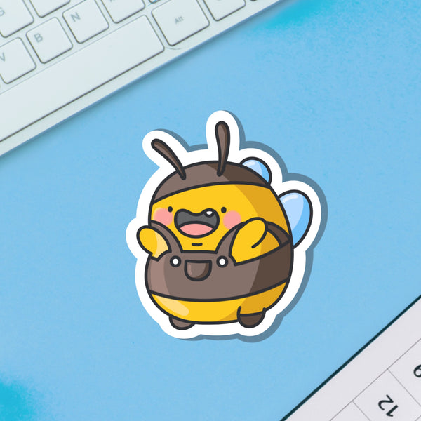 Bumblebee wearing dungarees vinyl sticker on blue table