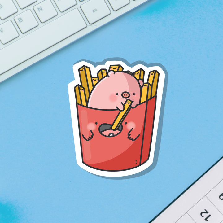 Pig sat in french fries vinyl sticker on blue table