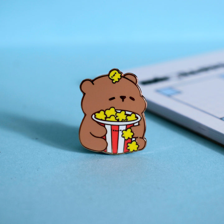 Popcorn bear enamel pin on table