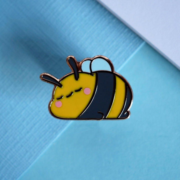 Sleeping bee pin on blue table