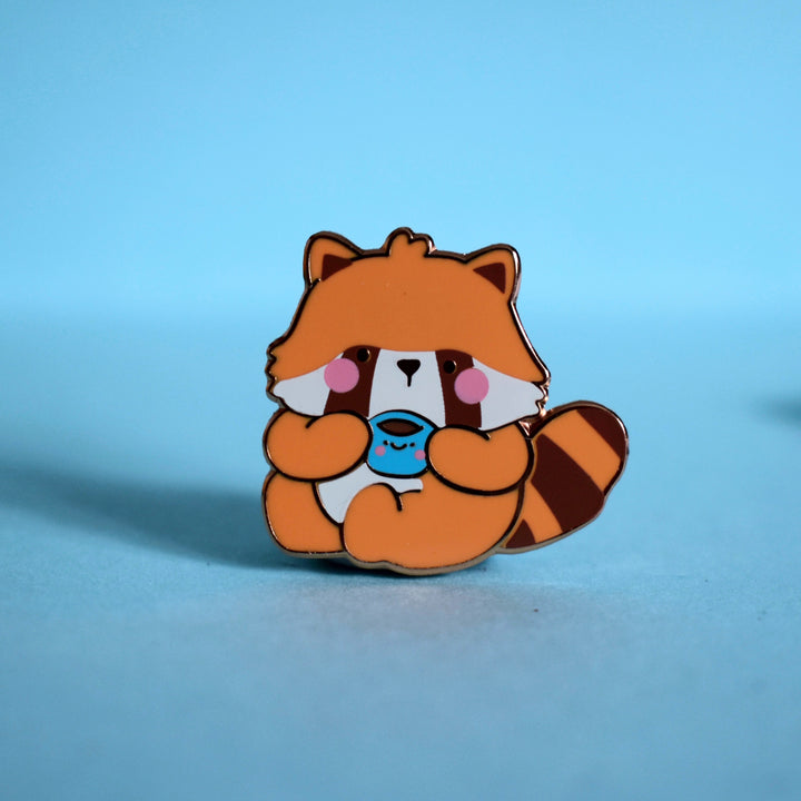 Red Panda enamel pin on blue table